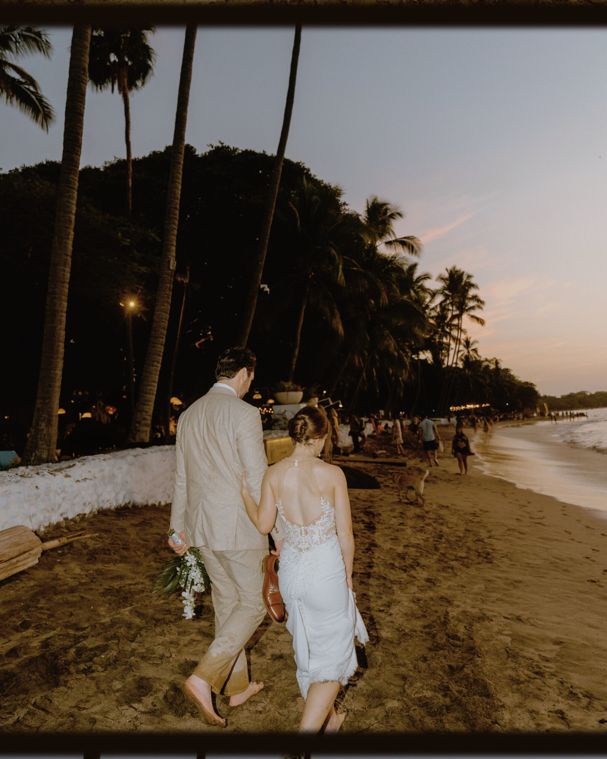 Bride and Groom walking on Beach during wedding day